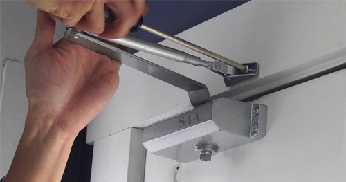 What is the difference between a door closer and a floor spring?